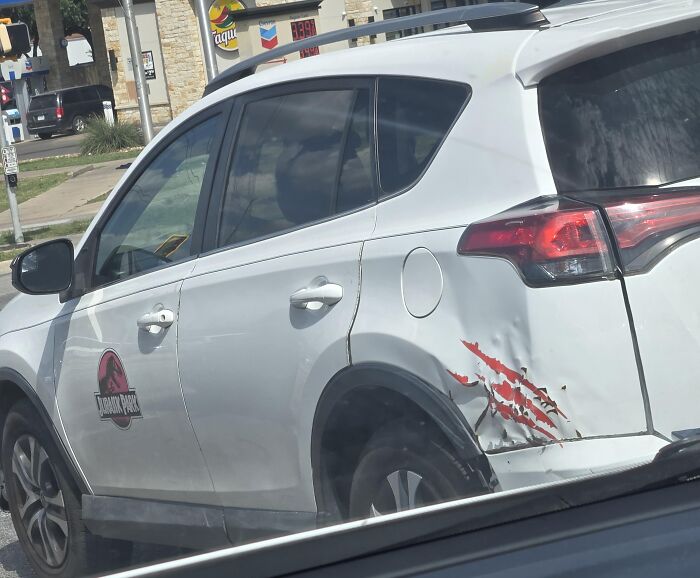 A white car with Jurassic Park logo and claw mark decals covering real damage as one of many absurd products.