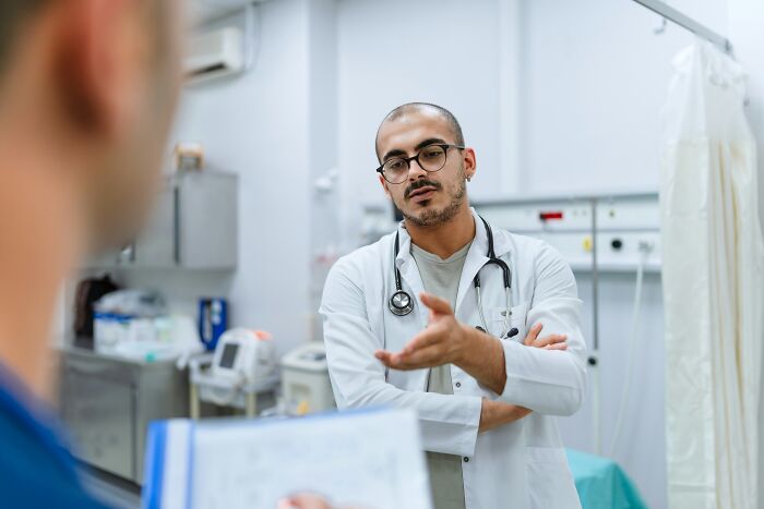 A doctor speaking with a patient in a medical room, depicting dumb things professionals said or did.