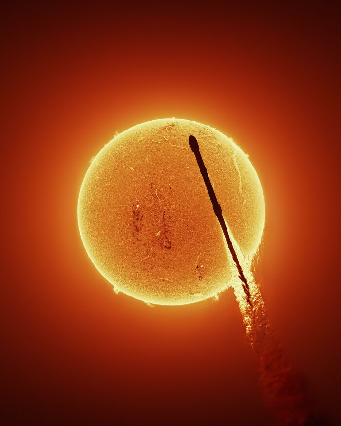 An interesting photo of a rocket silhouette passing in front of the sun